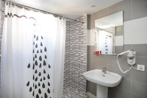 a bathroom with a sink and a shower curtain at Apartamentos Amalia By Mc in Benidorm
