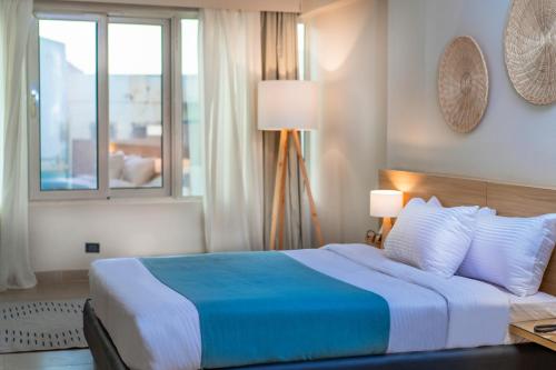 a bedroom with a blue and white bed with a window at Redcon Suites in Hurghada