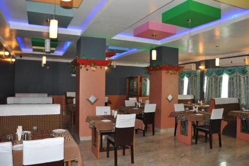 Un restaurante con mesas y sillas en una habitación. en Hotel Barbareek, en Shillong