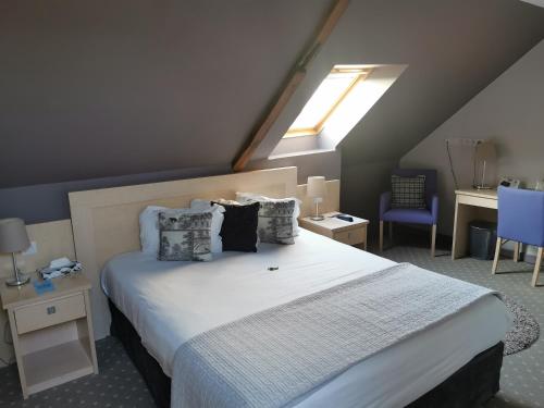 Grand-FougerayHÔTEL LES PALIS的卧室配有一张带白色床单和枕头的大床。