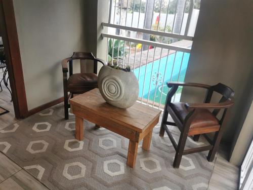 un jarrón sentado en una mesa junto a dos sillas en Harties Honeymoon Suite, en Hartbeespoort