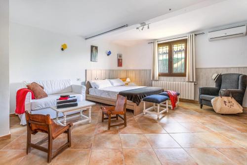 a living room with a couch and a bed and chairs at Chalet Can Singala in Port de Pollensa