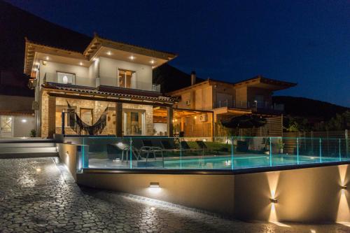 a house with a swimming pool at night at Serenity Penthouse in Chalkida