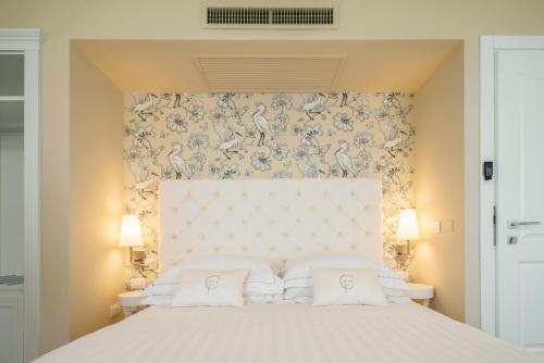 a white bed with a white comforter and pillows at Boutique Hotel Carlo Felice in Cagliari