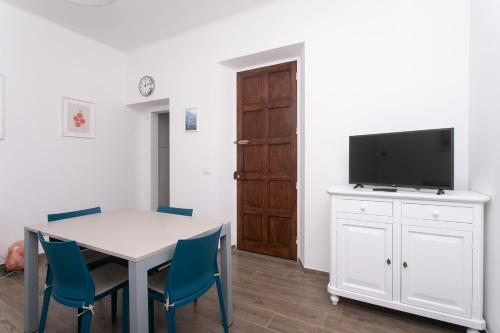 a room with a table with chairs and a tv at N237 - Numana, trilocale a 100 metri dal centro in Numana