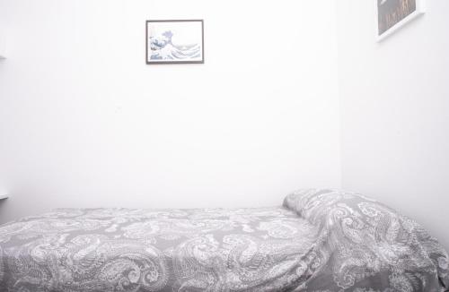 a bed in a white room with a picture on the wall at N237 - Numana, trilocale a 100 metri dal centro in Numana
