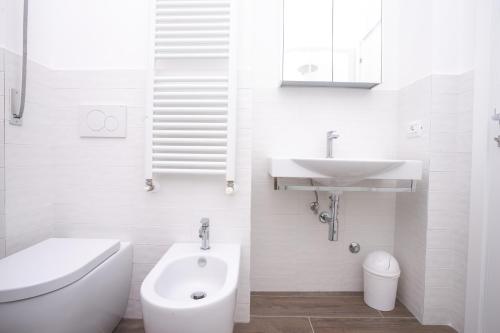 a white bathroom with a sink and a toilet at N237 - Numana, trilocale a 100 metri dal centro in Numana