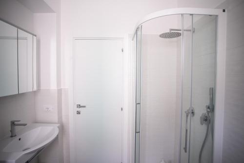 a white bathroom with a shower and a sink at N237 - Numana, trilocale a 100 metri dal centro in Numana