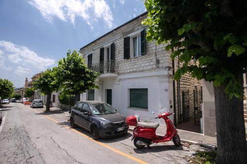 a red scooter and a car parked next to a building at N237 - Numana, trilocale a 100 metri dal centro in Numana
