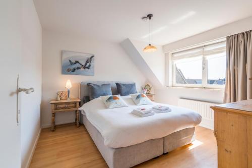 1 dormitorio con cama y ventana en Spacious, warm and updated Home w parking & garden, en Bredene
