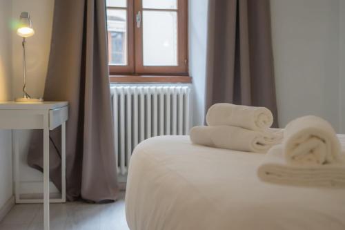 a bedroom with a bed with towels on it at Le Parmelan - apartment for 2 people in the heart of the old town in Annecy