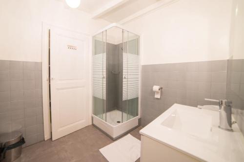 a white bathroom with a shower and a sink at Le Parmelan - apartment for 2 people in the heart of the old town in Annecy