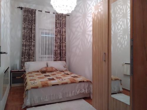 a bedroom with a bed with a cat laying on it at Apartman Centar in Banja Luka