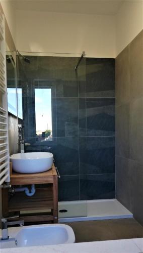 a bathroom with a sink and a glass shower at AMARE MATERA comfortable rooms in Matera