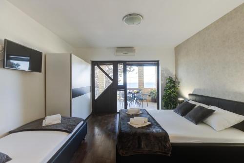 a bedroom with two beds and a balcony at Apartments Matia in Senj
