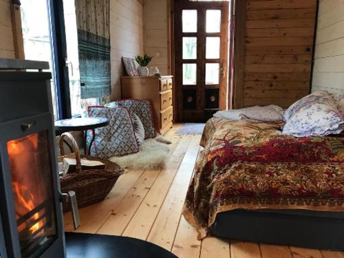 a bedroom with a bed and a fireplace in it at Der Zirkuswagen und das Elfenhaus in Dittmannsdorf