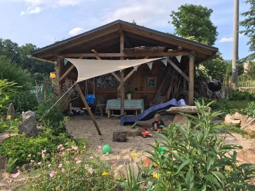 a tent in a garden with a child under it at Der Zirkuswagen und das Elfenhaus in Dittmannsdorf