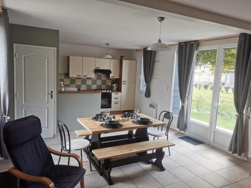 cocina y comedor con mesa y sillas en Le Village du Phare, en Gouville-sur-Mer