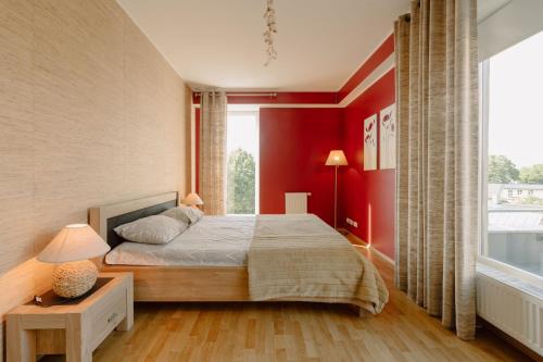 a bedroom with red walls and a bed and a window at Seaside Apartment in Haapsalu