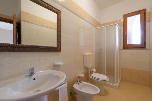 a bathroom with a sink and a toilet and a mirror at Tenuta Li Fani Residence Hotel in Marina di Pescoluse
