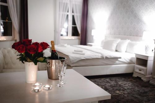 a bedroom with a bed and a table with a bottle of wine at Hotel Nadodrzański Dwór - Nowa Sól in Nowa Sól