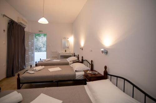 プラティスヤロス・シフノスにあるPrasini Goniaのベッド4台と窓が備わる部屋、