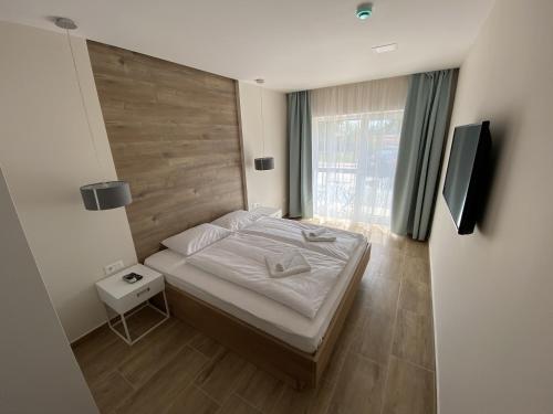 um quarto com uma cama e uma cabeceira em madeira em MAGNOLIA Room & Spa - ADULTS ONLY em Csopak