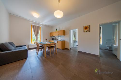 a living room with a table and chairs and a kitchen at Restaurace a Pension Hřebíkárna in Chomutov