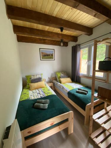 two beds in a room with two windows at Domek na Górce 660 704 280 in Baligród
