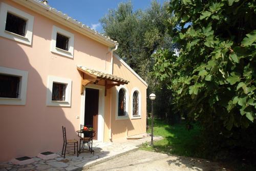 un tavolo e sedie seduti fuori da una casa di Villa Olive apartments a Ipsos
