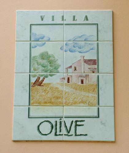 a tile wall with a picture of a village at Villa Olive apartments in Ipsos