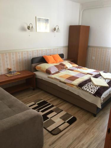 1 dormitorio con cama, mesa y sofá en Bükk Vendeghaz en Noszvaj
