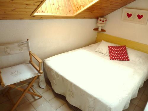 a bedroom with two beds and a chair at LES MOULINS DE LA GUISANE in La Salle-les-Alpes