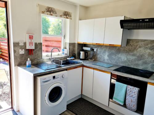 a kitchen with a washing machine and a sink at Aviemore Stay & Explore in Aviemore