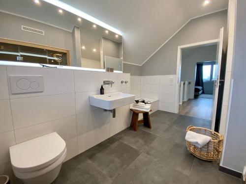 a white bathroom with a toilet and a sink at hey BEACHVILLA in Hohwacht