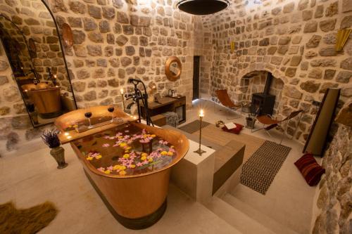 a large bath tub filled with flowers in a room at Mirsoum Hotels in Mardin