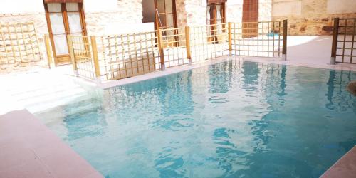 a swimming pool with blue water in a building at MANZANO PALACE. Habitaciones y Suites 30 m2 en la Plaza Mayor in Almagro