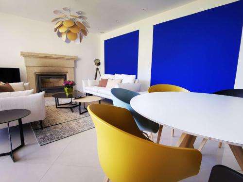 a dining room with white tables and yellow chairs at Domaine de Stang Bihan in Concarneau