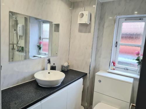 a bathroom with a sink and a toilet and a mirror at Aviemore Stay & Explore in Aviemore