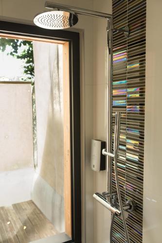 a bathroom with a window and a glass shower at HÔTEL LES PALIS in Grand-Fougeray
