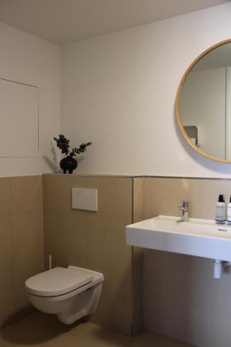 a bathroom with a toilet and a sink and a mirror at Hotel Paradis Zandvoort in Zandvoort