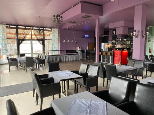 um restaurante com paredes roxas, mesas e cadeiras em Graal SPA em Świnoujście