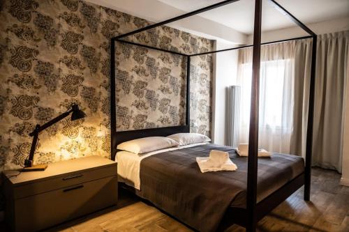 a bedroom with a canopy bed and a dresser with a lamp at Trevisi27 in Treviso