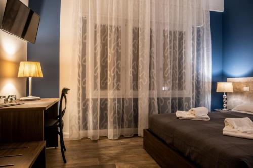a bedroom with a desk and a bed with a curtain at Trevisi27 in Treviso