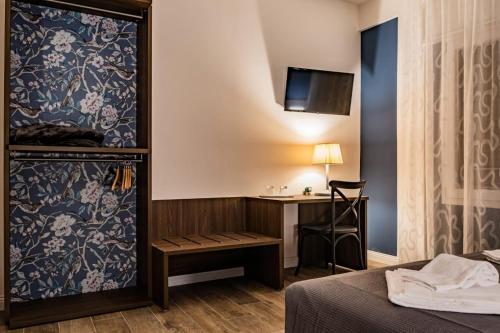 a room with a bed and a desk with a monitor at Trevisi27 in Treviso