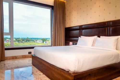 um quarto com uma cama grande e uma janela grande em ECONEST HOTEL em Tarapith