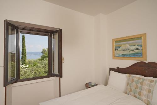 a bedroom with a bed and a window with a view at Villa Bouganville in Toscolano Maderno
