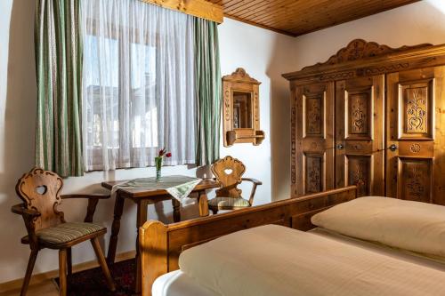 a bedroom with a bed and a table and a window at "Kaiser Karl" *** Ferienwohnungen in Grossgmain
