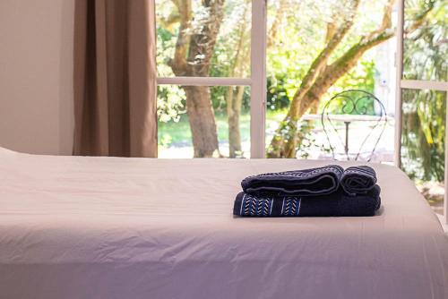 a pair of towels sitting on top of a bed at Au détour des vignes in Ordonnac