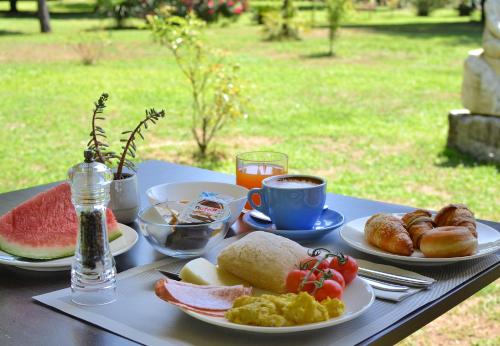 una mesa con platos de comida y una taza de café en Hotel Villa Elsa, en Marina di Massa